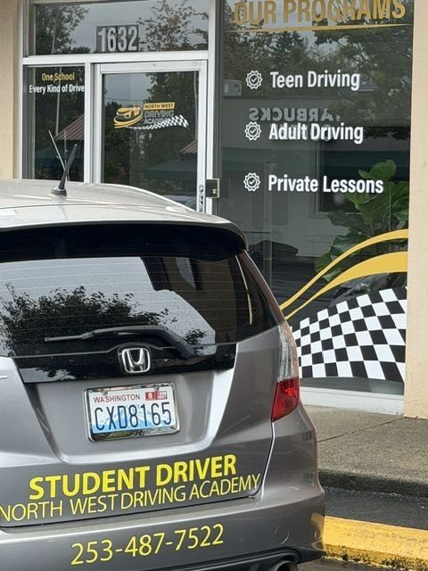 A North West Driving Academy student driver training vehicle parked outside the school
